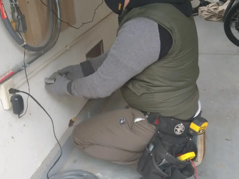 Electrician performing outlet wiring in a Centerville garage